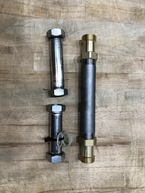 Drei Rohrstücke aus Metall mit verschiedenen Verbindungsenden, die für Heizungsanwendungen vorgesehen sind. Teile sind möglicherweise von Danfoss.
